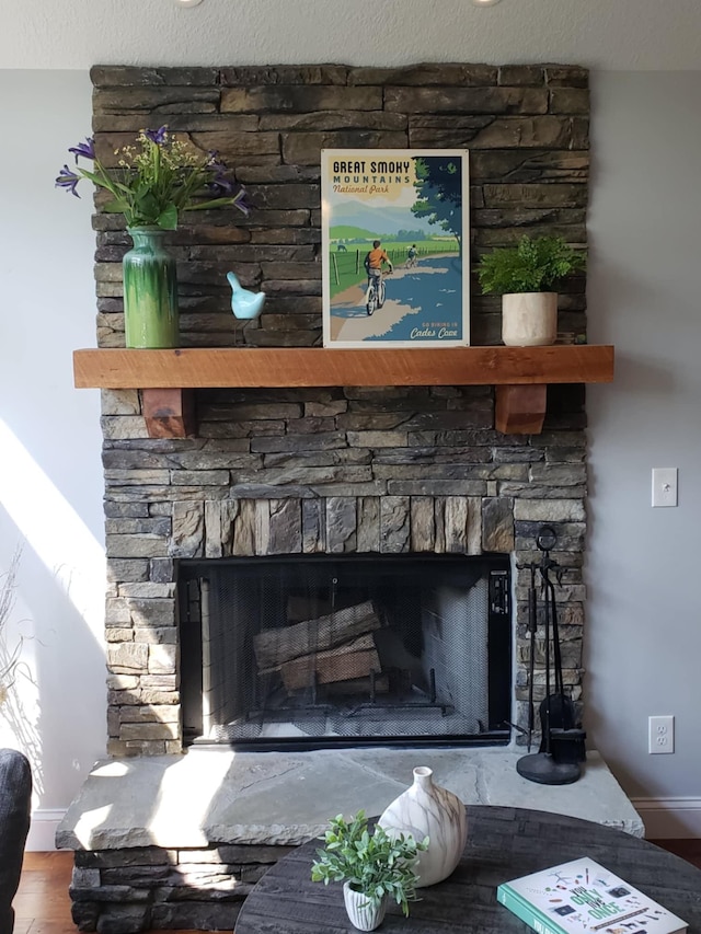 room details featuring a stone fireplace, a textured ceiling, and hardwood / wood-style floors