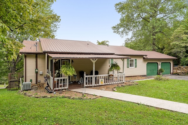 view of front of property with a garage, cooling unit, and a front yard