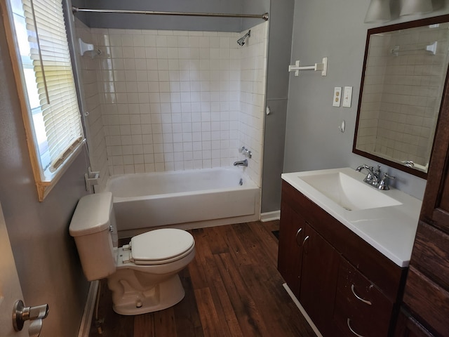 full bathroom with hardwood / wood-style floors, tiled shower / bath combo, toilet, and vanity