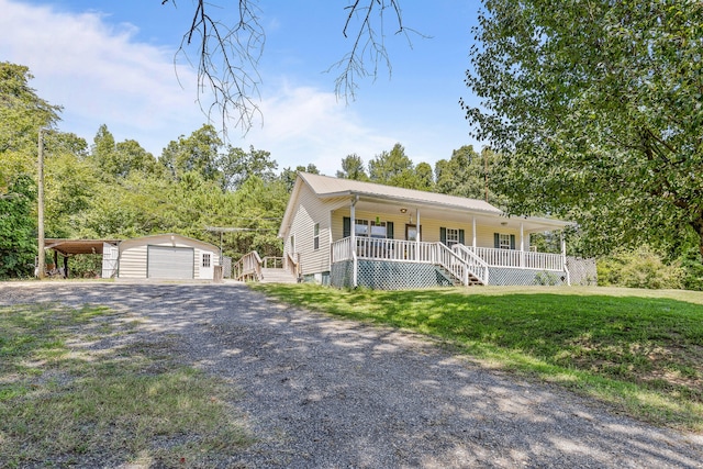 view of front facade with an outbuilding, a front yard, a garage, and a porch