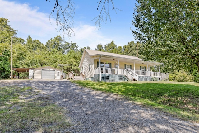 view of front of property with a garage, driveway, metal roof, an outbuilding, and a porch