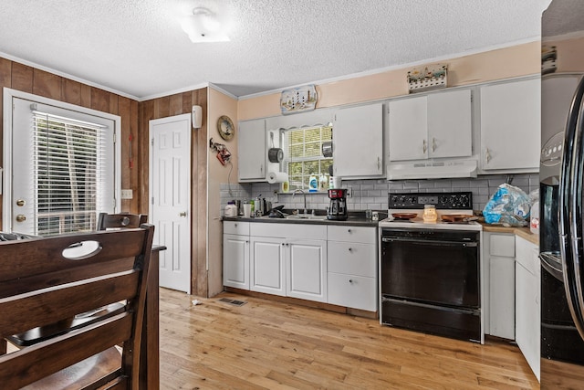 kitchen with black appliances, ornamental molding, a textured ceiling, and light hardwood / wood-style flooring