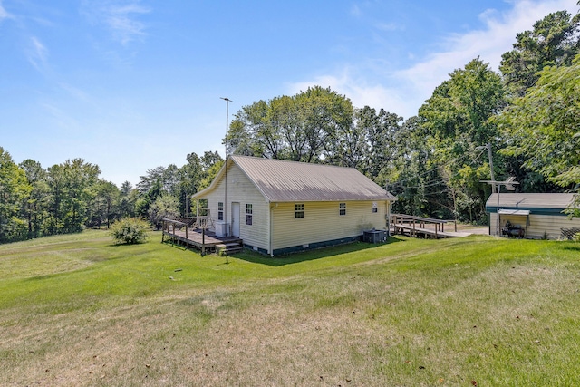 view of side of property featuring cooling unit, a lawn, and a wooden deck