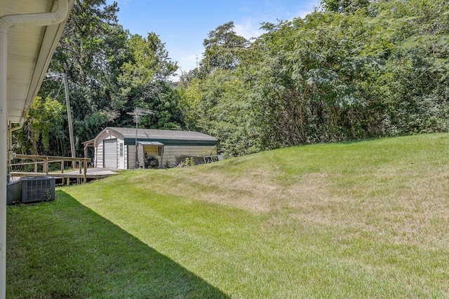 view of yard featuring central AC unit and a shed