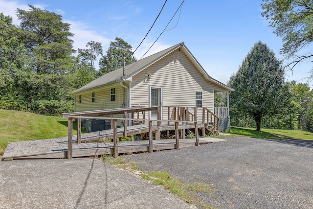 view of front facade with a deck and a front yard