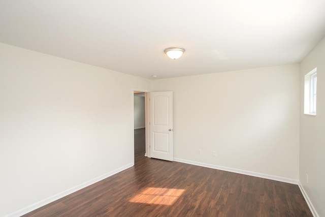 unfurnished room with dark wood-type flooring