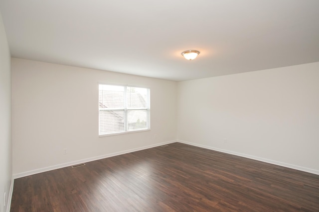 spare room with dark wood-type flooring