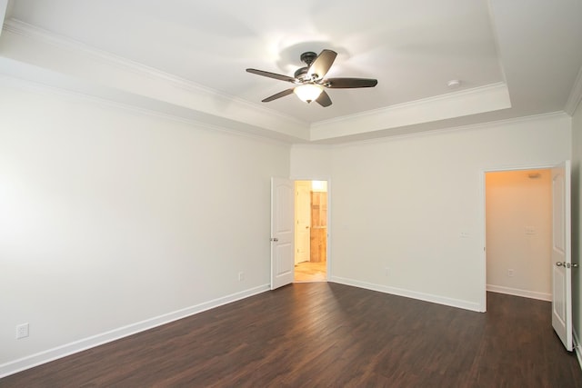 spare room featuring ceiling fan, a raised ceiling, dark hardwood / wood-style floors, and crown molding