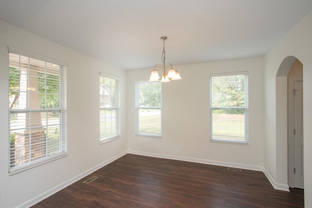 empty room with a chandelier and dark hardwood / wood-style floors