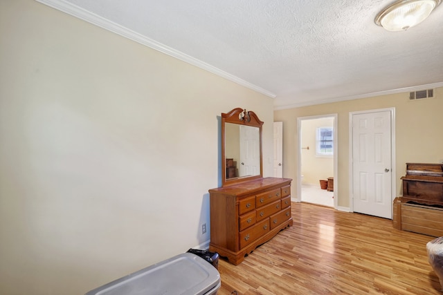 bedroom featuring crown molding, a textured ceiling, and light hardwood / wood-style floors