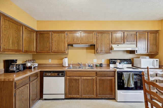 kitchen with sink, white appliances, and a textured ceiling