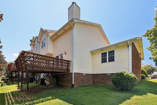 back of house with central air condition unit, a deck, and a lawn