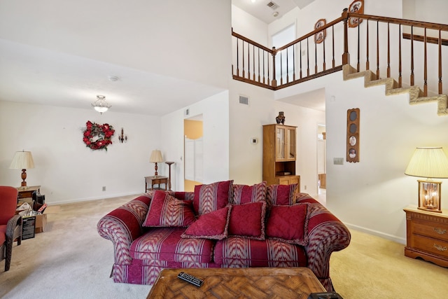 living room with a towering ceiling and light colored carpet