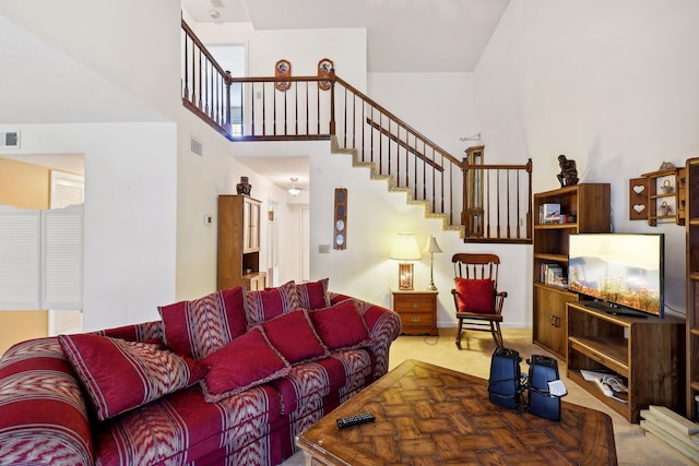 carpeted living room featuring a high ceiling