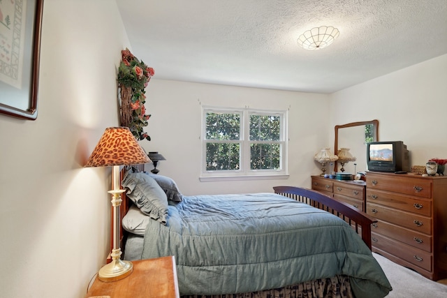 bedroom featuring carpet flooring and a textured ceiling