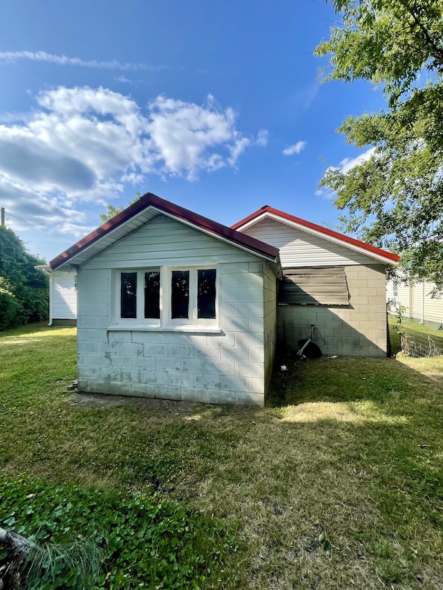 view of side of home with a lawn