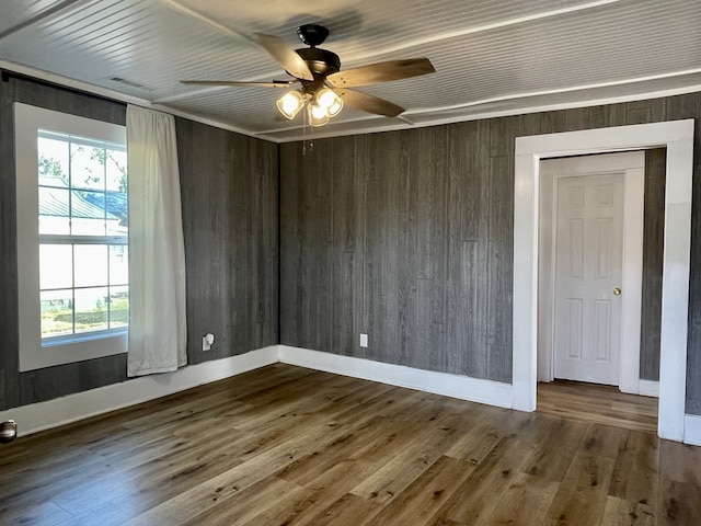 spare room with plenty of natural light, ceiling fan, and hardwood / wood-style floors