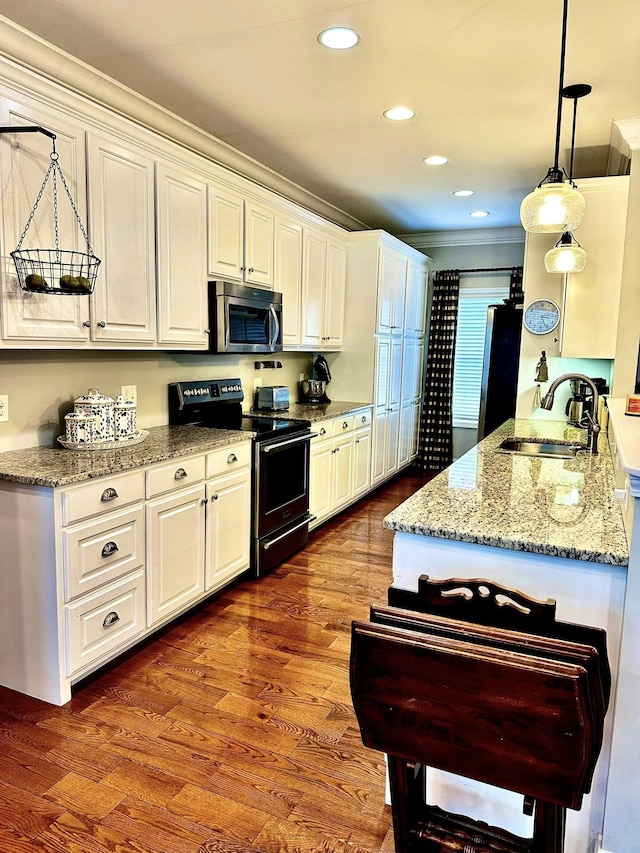 kitchen featuring sink, fridge, wood-type flooring, black electric range oven, and hanging light fixtures