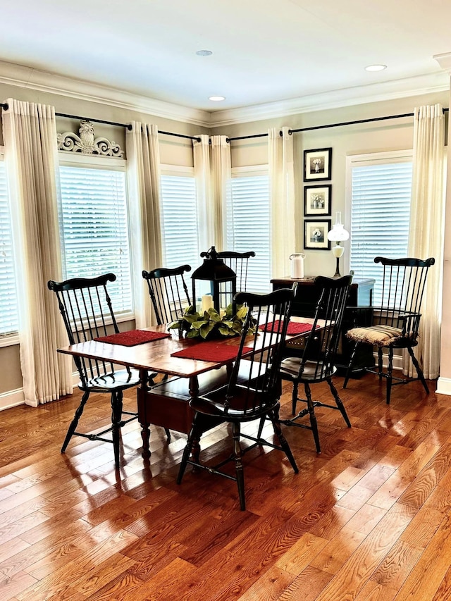 dining space featuring ornamental molding, plenty of natural light, and wood-type flooring