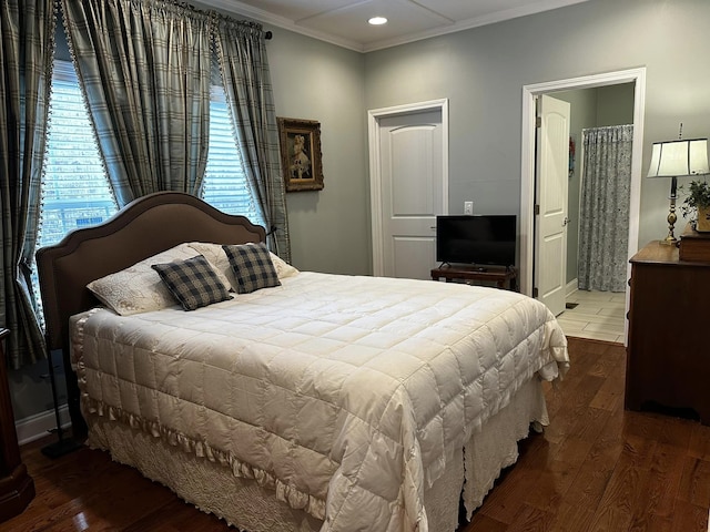 bedroom with hardwood / wood-style floors, crown molding, and ensuite bathroom