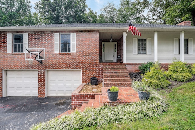 view of front of home with a garage and central air condition unit