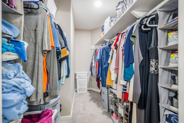 walk in closet with light carpet