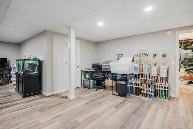 home office featuring light wood-type flooring and a drop ceiling