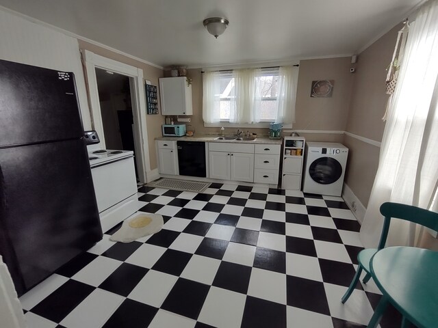 kitchen with sink, dark tile patterned flooring, black appliances, washer / clothes dryer, and white cabinets