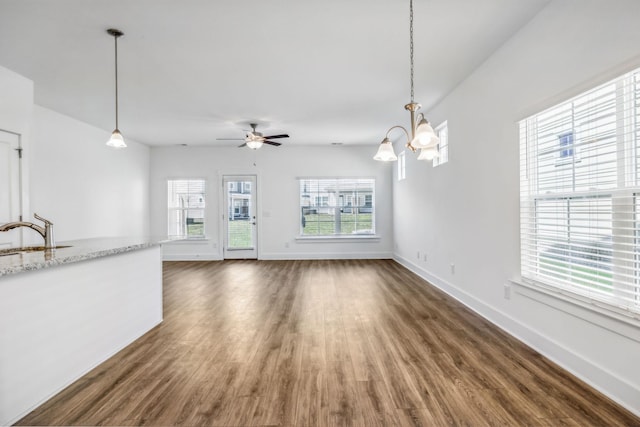 unfurnished living room featuring sink, ceiling fan, and dark hardwood / wood-style flooring