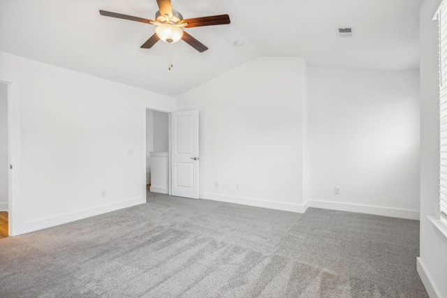 carpeted empty room featuring vaulted ceiling and ceiling fan