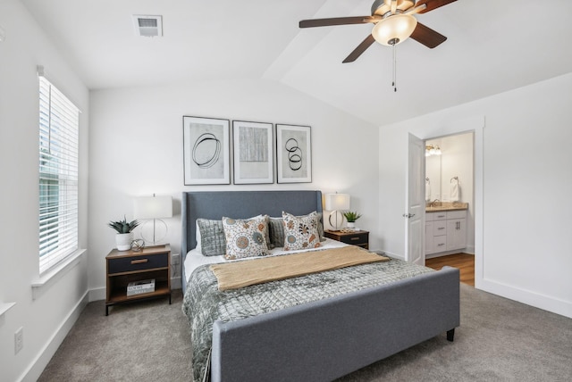 carpeted bedroom with ceiling fan, connected bathroom, and lofted ceiling