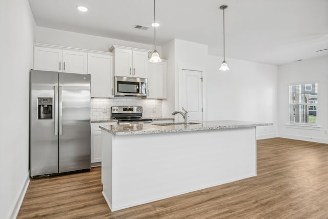 kitchen featuring sink, light hardwood / wood-style flooring, an island with sink, white cabinetry, and stainless steel appliances