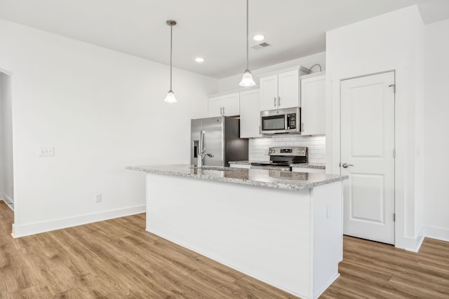 kitchen featuring light hardwood / wood-style flooring, decorative backsplash, an island with sink, stainless steel appliances, and white cabinets