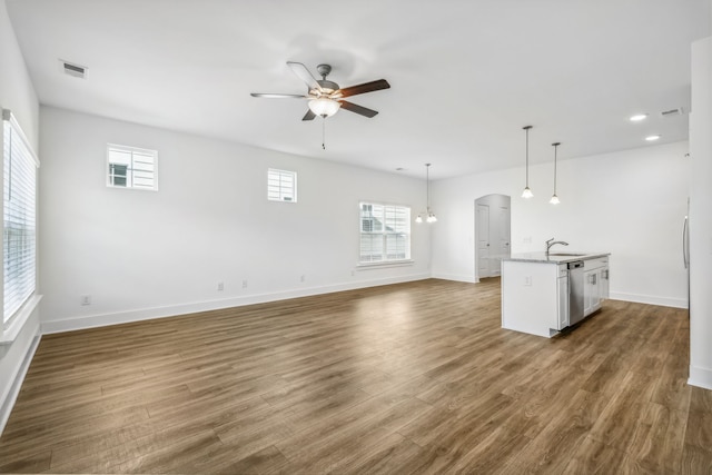 unfurnished living room featuring sink, ceiling fan, and hardwood / wood-style floors