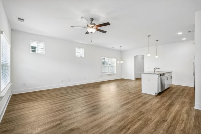 unfurnished living room with ceiling fan, sink, and dark hardwood / wood-style flooring