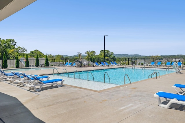 view of swimming pool with a mountain view and a patio