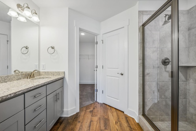 bathroom with a shower with door, vanity, and wood-type flooring