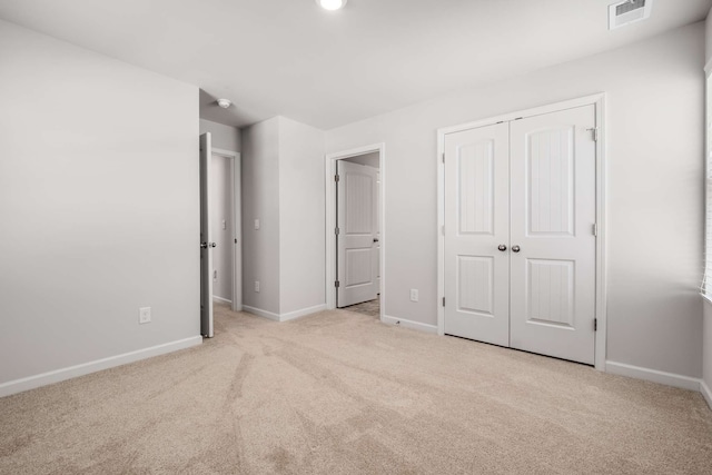 unfurnished bedroom with a closet and light carpet