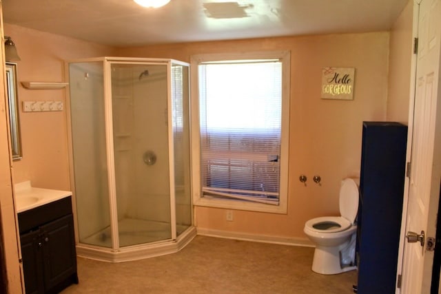 bathroom with vanity, toilet, and a shower with door