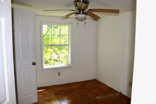 empty room featuring dark parquet floors and ceiling fan