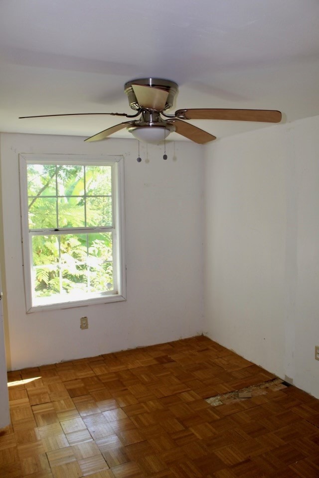 spare room featuring parquet flooring and ceiling fan