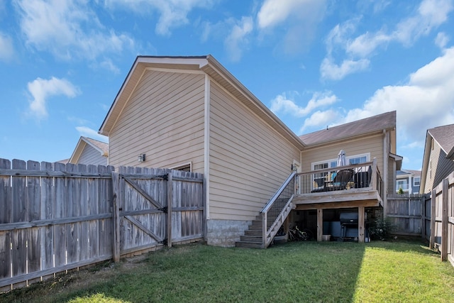 back of property with a deck and a yard