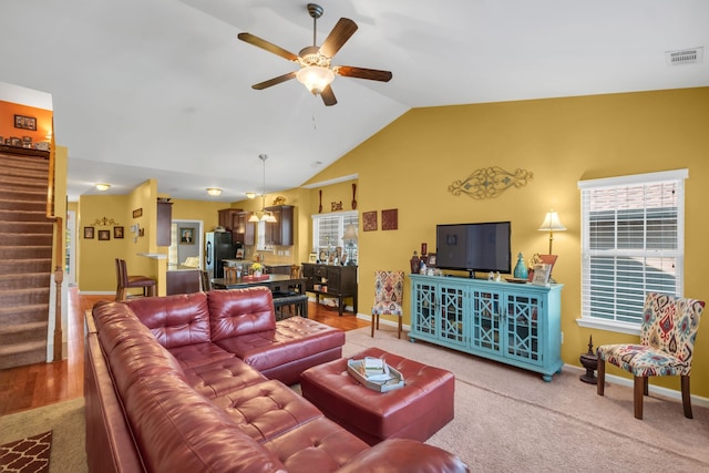 carpeted living room featuring ceiling fan and lofted ceiling