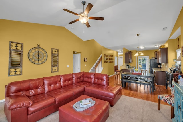 carpeted living room featuring ceiling fan and vaulted ceiling