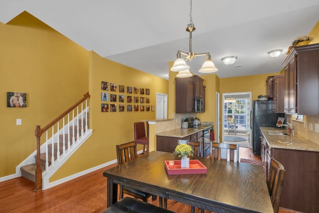 dining room with dark hardwood / wood-style floors, sink, and a chandelier