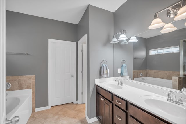 bathroom featuring tile patterned flooring, vanity, and a tub to relax in