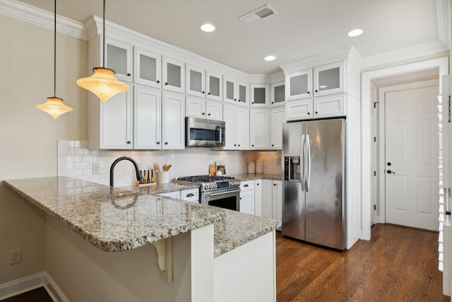 kitchen with kitchen peninsula, hanging light fixtures, white cabinets, and stainless steel appliances