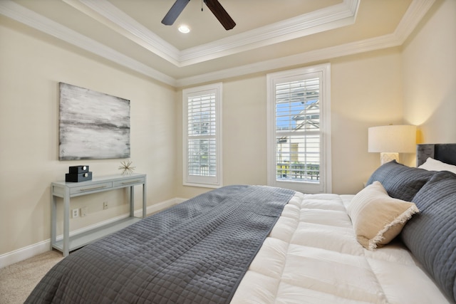 carpeted bedroom featuring ceiling fan, a raised ceiling, and ornamental molding