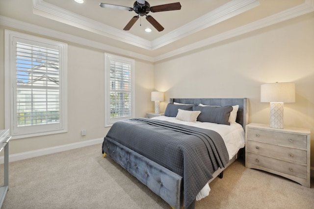 carpeted bedroom featuring a tray ceiling, ceiling fan, and ornamental molding