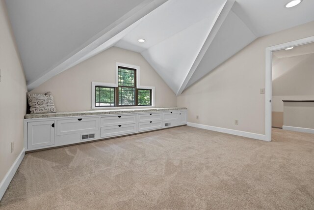 additional living space with vaulted ceiling and light carpet